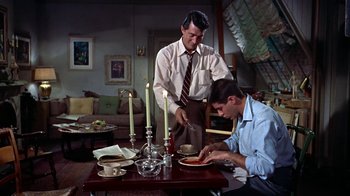 Movie still from “Artists and Models” (1955), directed by Frank Tashlin – Two men are preparing a meal at a dinner table; Medium shot, High angle