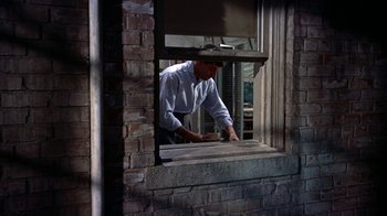 Movie still from “Artists and Models” (1955), directed by Frank Tashlin – A man standing in front of an open window; Medium shot, Low angle
