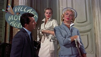 Movie still from “Artists and Models” (1955), directed by Frank Tashlin – A man and two women standing next to each other; Medium shot, Low angle