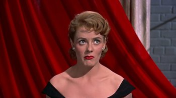 Movie still from “Artists and Models” (1955), directed by Frank Tashlin – A person wearing a black dress; Close Up shot, Over the shoulder angle