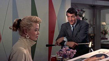 Movie still from “Artists and Models” (1955), directed by Frank Tashlin – A man and a woman are sitting at a table; Medium shot, Over the shoulder angle