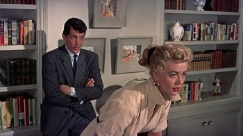 Movie still from “Artists and Models” (1955), directed by Frank Tashlin – A man and a woman sitting in front of each other in a room; Medium shot, Low angle