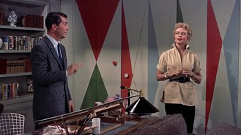 Movie still from “Artists and Models” (1955), directed by Frank Tashlin – A man and a woman standing next to a table; Medium shot, Low angle