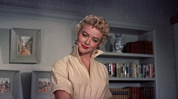 Movie still from “Artists and Models” (1955), directed by Frank Tashlin – A woman with blonde curly hair wearing a beige shirt; Close Up shot, Low angle