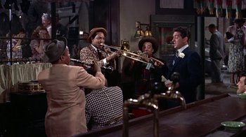 Movie still from “Artists and Models” (1955), directed by Frank Tashlin – A group of people playing musical instruments in a room; Wide shot, High angle