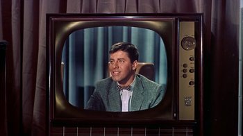 Movie still from “Artists and Models” (1955), directed by Frank Tashlin – A man sitting in a chair in front of a television; Close Up shot, Over the shoulder angle