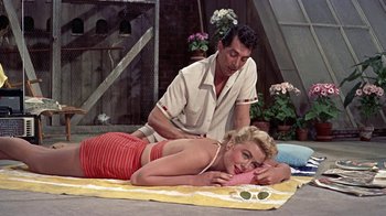 Movie still from “Artists and Models” (1955), directed by Frank Tashlin – A man and a woman laying on a towel; Medium shot, Overhead angle