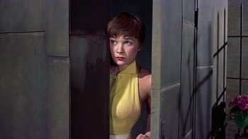Movie still from “Artists and Models” (1955), directed by Frank Tashlin – A woman in a yellow top standing in a doorway; Medium shot, Low angle