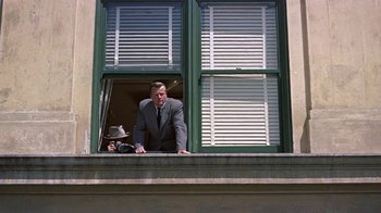 Movie still from “Artists and Models” (1955), directed by Frank Tashlin – A man in a suit looking out of a window; Wide shot, Low angle