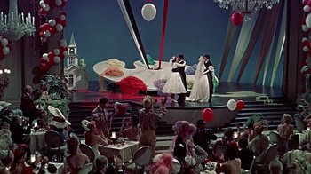 Movie still from “Artists and Models” (1955), directed by Frank Tashlin – A group of people standing on a stage with balloons; Extreme Wide shot, High angle