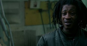 Movie still from “Babylon” (1980), directed by Franco Rosso – A person with dreadlocks wearing a jacket; Close Up shot, Low angle
