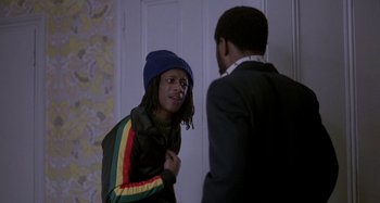 Movie still from “Babylon” (1980), directed by Franco Rosso – Two young men are talking in a room; Medium shot, Over the shoulder angle