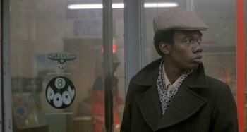 Movie still from “Babylon” (1980), directed by Franco Rosso – A man wearing a hat and a coat; Close Up shot, Low angle