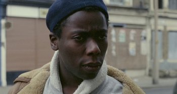 Movie still from “Babylon” (1980), directed by Franco Rosso – A person wearing a hat; Close Up shot, High angle