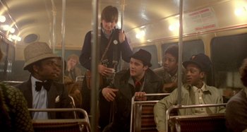 Movie still from “Babylon” (1980), directed by Franco Rosso – A group of people riding on a public transit bus; Medium shot, High angle
