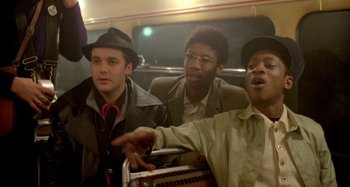 Movie still from “Babylon” (1980), directed by Franco Rosso – A group of men riding on a bus together; Medium shot, Low angle