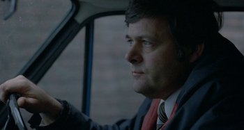 Movie still from “Babylon” (1980), directed by Franco Rosso – A man sitting in the driver's seat of a car; Close Up shot, Low angle