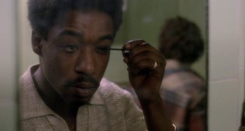 Movie still from “Babylon” (1980), directed by Franco Rosso – A person holding a pen in his hand; Close Up shot, Over the shoulder angle