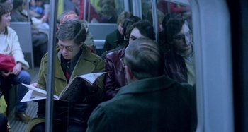 Movie still from “Babylon” (1980), directed by Franco Rosso – A group of people riding on a bus with an umbrella; Medium shot, High angle
