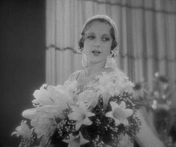 Movie still from “Bad Girl” (1931), directed by Frank Borzage – An old photo of a woman holding a bouquet of flowers; Close Up shot, Low angle