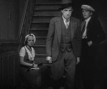 Movie still from “Bad Girl” (1931), directed by Frank Borzage – An old photo of a woman and two men; Medium shot, High angle