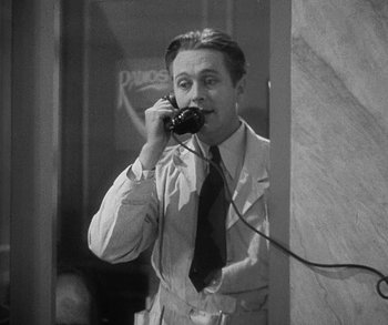 Movie still from “Bad Girl” (1931), directed by Frank Borzage – A black and white photo of a man talking on a phone; Medium shot, High angle