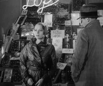 Movie still from “Bad Girl” (1931), directed by Frank Borzage – A man and a woman standing next to each other in a store; Medium shot, Over the shoulder angle