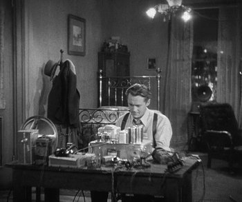 Movie still from “Bad Girl” (1931), directed by Frank Borzage – A man sitting at a table in a room; Medium shot, High angle