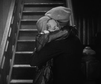 Movie still from “Bad Girl” (1931), directed by Frank Borzage – A man and a woman kissing in front of a staircase; Medium shot, High angle