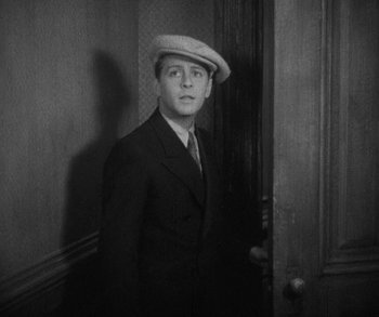 Movie still from “Bad Girl” (1931), directed by Frank Borzage – A black and white photo of a man wearing a hat; Medium shot, High angle