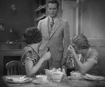 Movie still from “Bad Girl” (1931), directed by Frank Borzage – A man standing in front of two women at a dinner table; Medium shot, Over the shoulder angle
