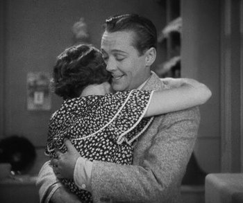 Movie still from “Bad Girl” (1931), directed by Frank Borzage – An old photo of a man and a woman hugging; Medium shot, High angle