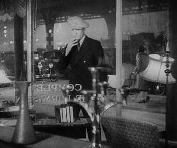 Movie still from “Bad Girl” (1931), directed by Frank Borzage – An old photo of a man smoking a cigarette; Medium shot, High angle