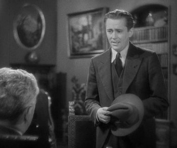 Movie still from “Bad Girl” (1931), directed by Frank Borzage – A man in a suit and tie holding a hat; Medium shot, Over the shoulder angle