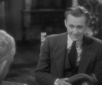 Movie still from “Bad Girl” (1931), directed by Frank Borzage – A man in a suit and tie sitting at a table; Medium shot, Over the shoulder angle