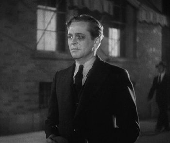 Movie still from “Bad Girl” (1931), directed by Frank Borzage – A black and white photo of a man in a suit and tie; Medium shot, Low angle