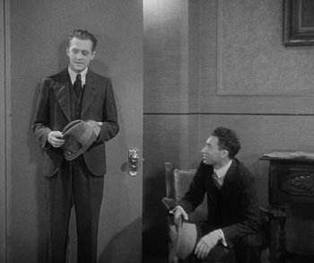 Movie still from “Bad Girl” (1931), directed by Frank Borzage – A man in a suit standing next to another man in a suit; Medium shot, High angle