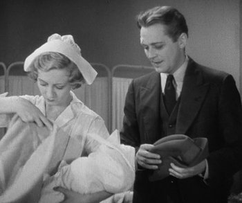 Movie still from “Bad Girl” (1931), directed by Frank Borzage – A man and a woman standing next to each other in a room; Medium shot, Low angle
