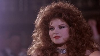 Movie still from “Blaze” (1989), directed by Ron Shelton – A person with long red hair; Close Up shot, Low angle