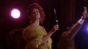 Movie still from “Blaze” (1989), directed by Ron Shelton – A woman in a yellow fur coat holding a hair brush; Close Up shot, Low angle