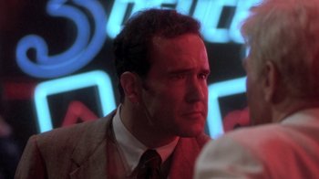 Movie still from “Blaze” (1989), directed by Ron Shelton – A person wearing a suit and tie; Close Up shot, Over the shoulder angle