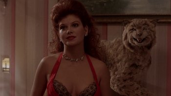 Movie still from “Blaze” (1989), directed by Ron Shelton – A woman in a red dress and a teddy bear in a room; Close Up shot, Low angle
