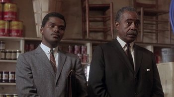 Movie still from “Blaze” (1989), directed by Ron Shelton – Two men standing next to each other wearing suits and ties; Medium shot, Low angle