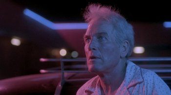 Movie still from “Blaze” (1989), directed by Ron Shelton – An older man sitting in the back seat of a car; Close Up shot, Low angle
