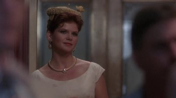 Movie still from “Blaze” (1989), directed by Ron Shelton – A person wearing a hat and a necklace; Close Up shot, Over the shoulder angle