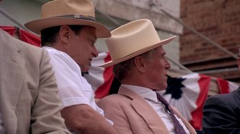 Movie still from “Blaze” (1989), directed by Ron Shelton – A couple of men wearing hats and suits; Medium shot, Over the shoulder angle