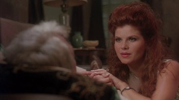 Movie still from “Blaze” (1989), directed by Ron Shelton – A woman sitting in front of a man holding his hand; Close Up shot, Over the shoulder angle