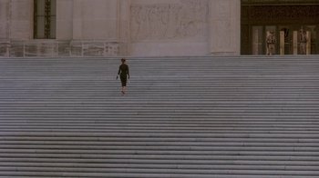 Movie still from “Blaze” (1989), directed by Ron Shelton – A woman walking up a set of stairs; Extreme Wide shot, High angle