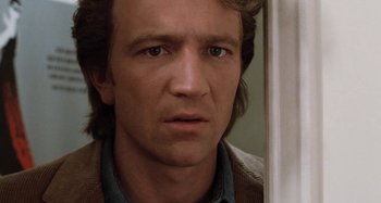 Movie still from “Body Double” (1984), directed by Brian De Palma – A man's face as he looks into a mirror; Close Up shot, Low angle