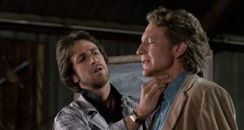 Movie still from “Body Double” (1984), directed by Brian De Palma – A man is putting a tie on another man's neck; Close Up shot, Over the shoulder angle